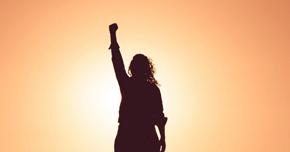 lone profile of woman holding up fist in victory